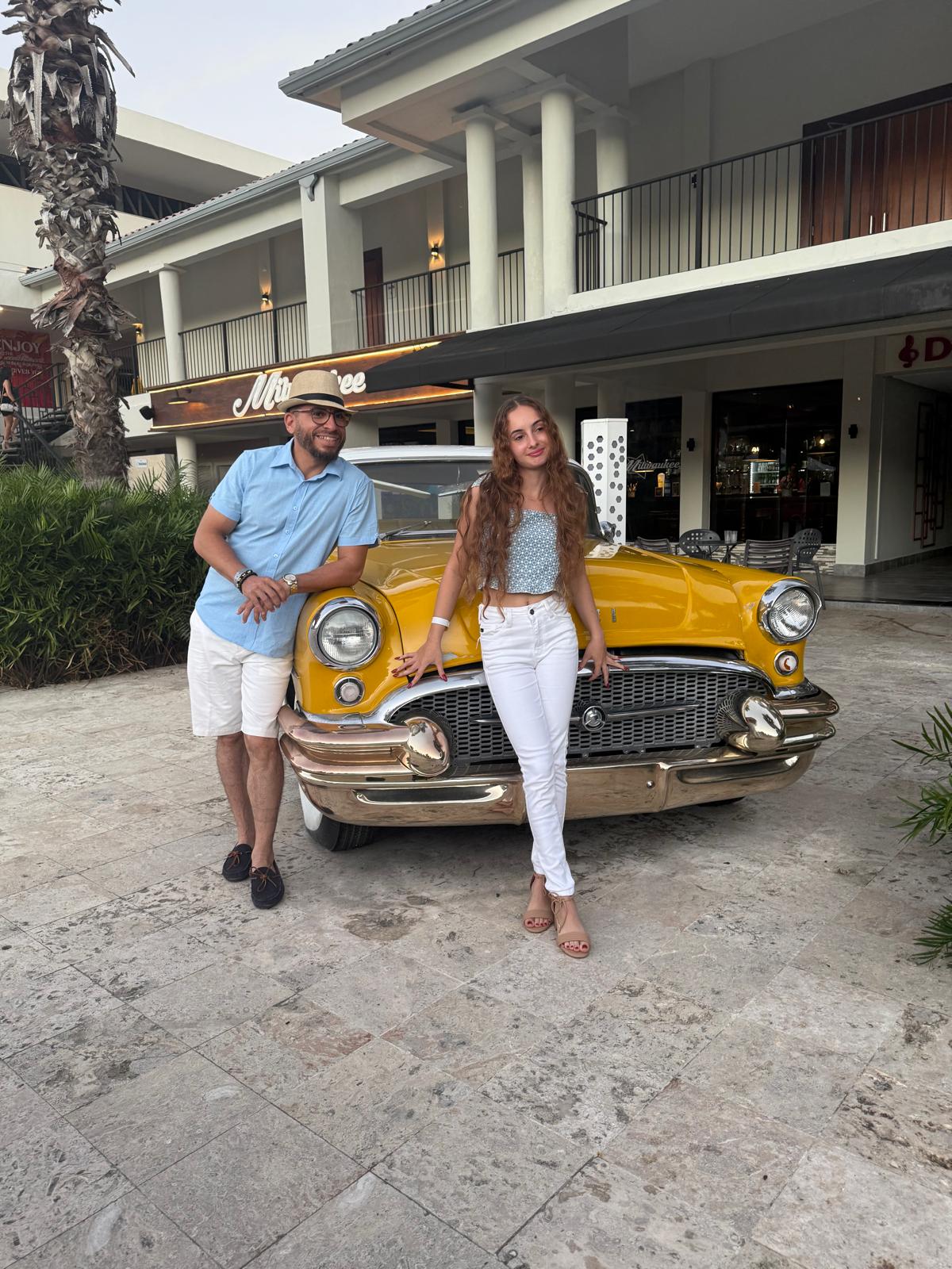 José Miguel y Amanda junto a un auto clásico amarillo